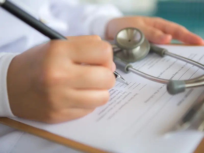 Médico completando una prescripción para un amparo de salud